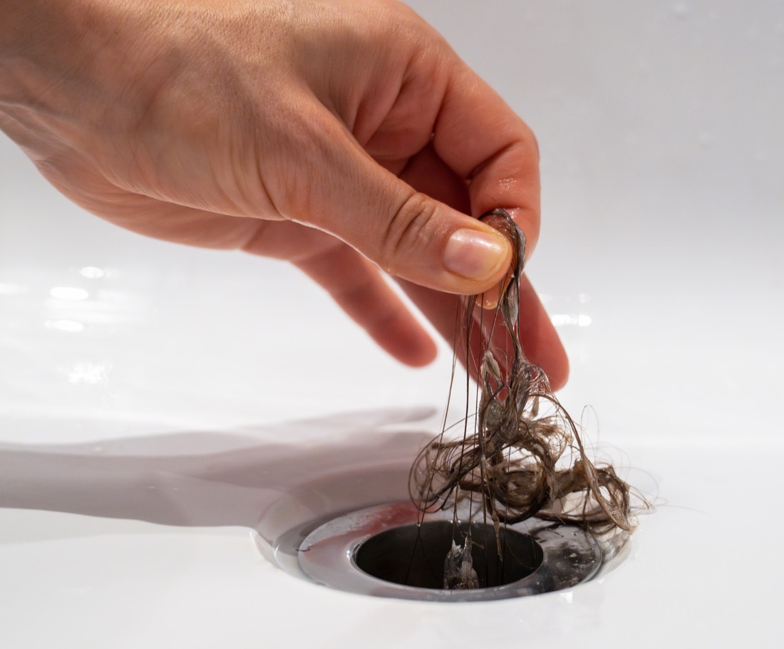 Hair being pulled from a blocked bath plughole